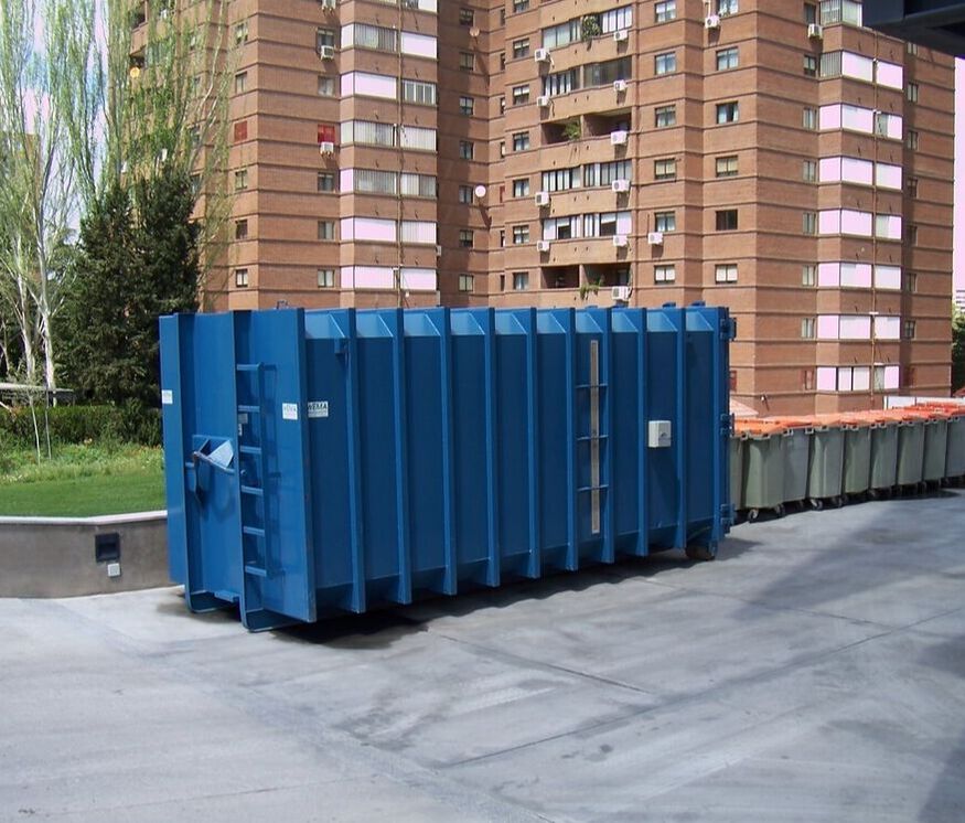 large blue residential dumpster situated on a street